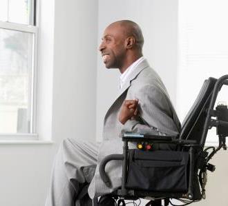 A black man with cerebral palsy sitting in a wheelchair