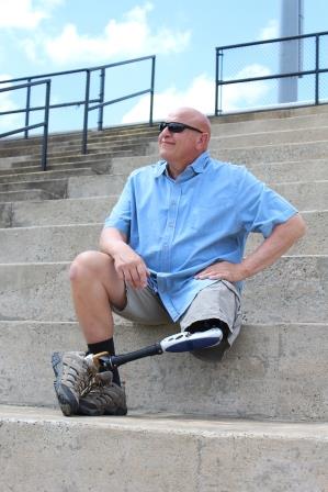 A man with a prosthetic leg sitting on the bleachers