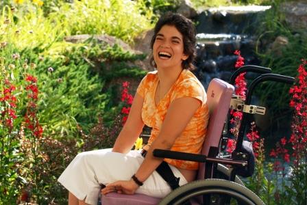 female wheelchair user in a garden, lauging